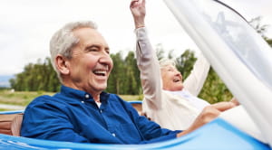 Should you buy a convertible car senior couple driving convertible smiling